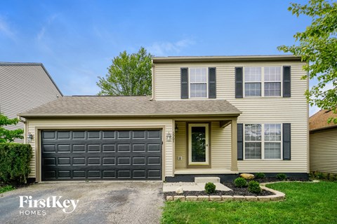 A house with a garage door and a sign that says "FirstKey Homes".