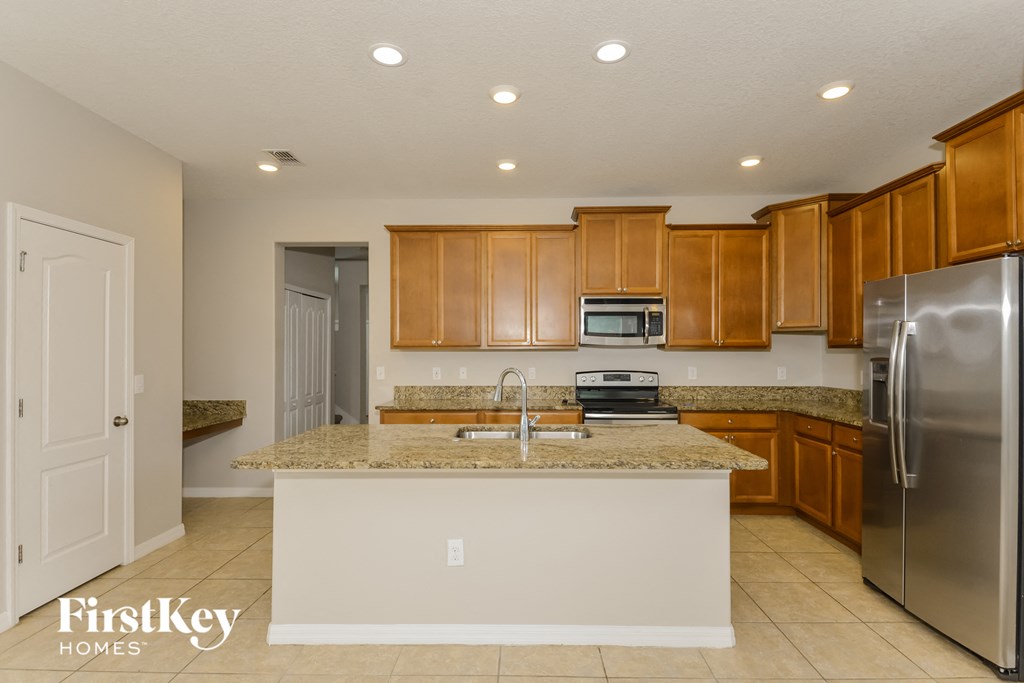 a kitchen with a granite counter top and a stainless steel refrigerator