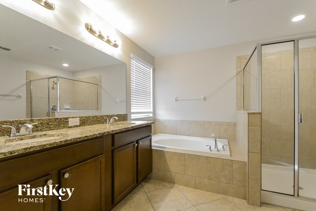 a bathroom with a tub and a sink and a mirror