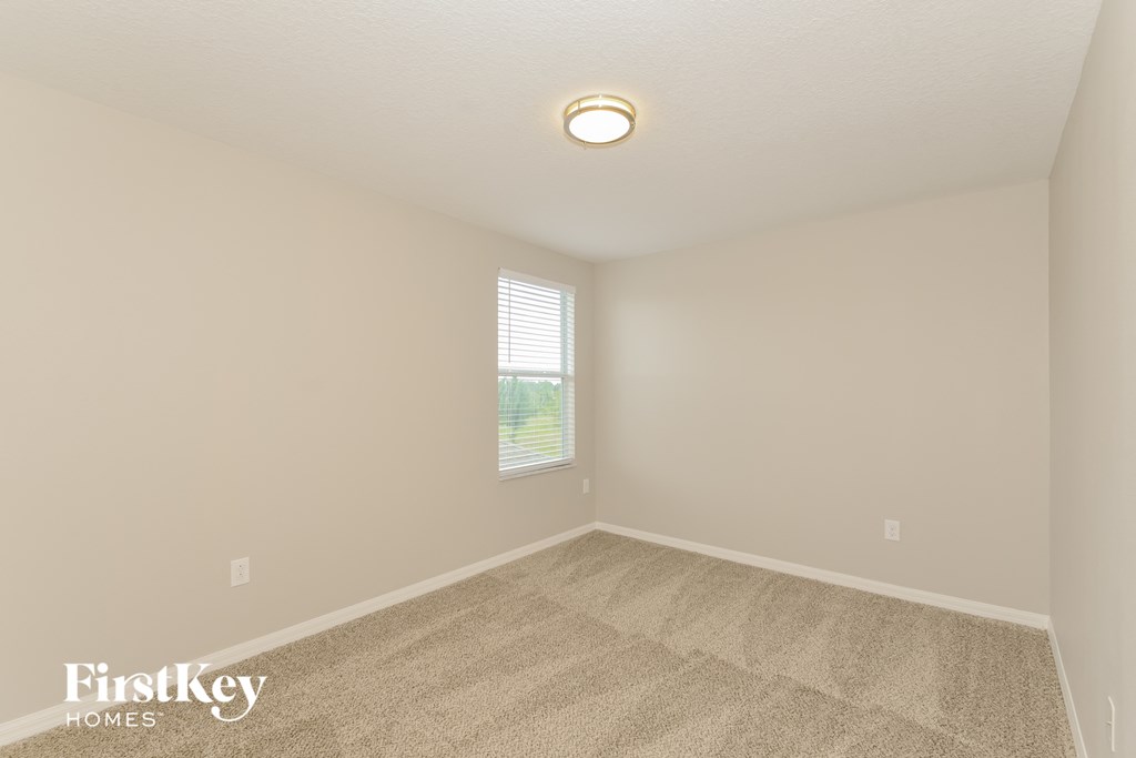 a spacious living room with carpet and a window