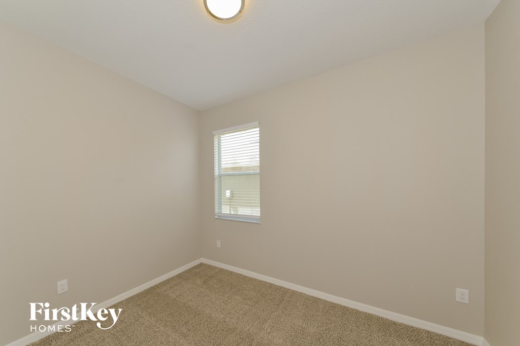 a bedroom with a carpeted floor and a window