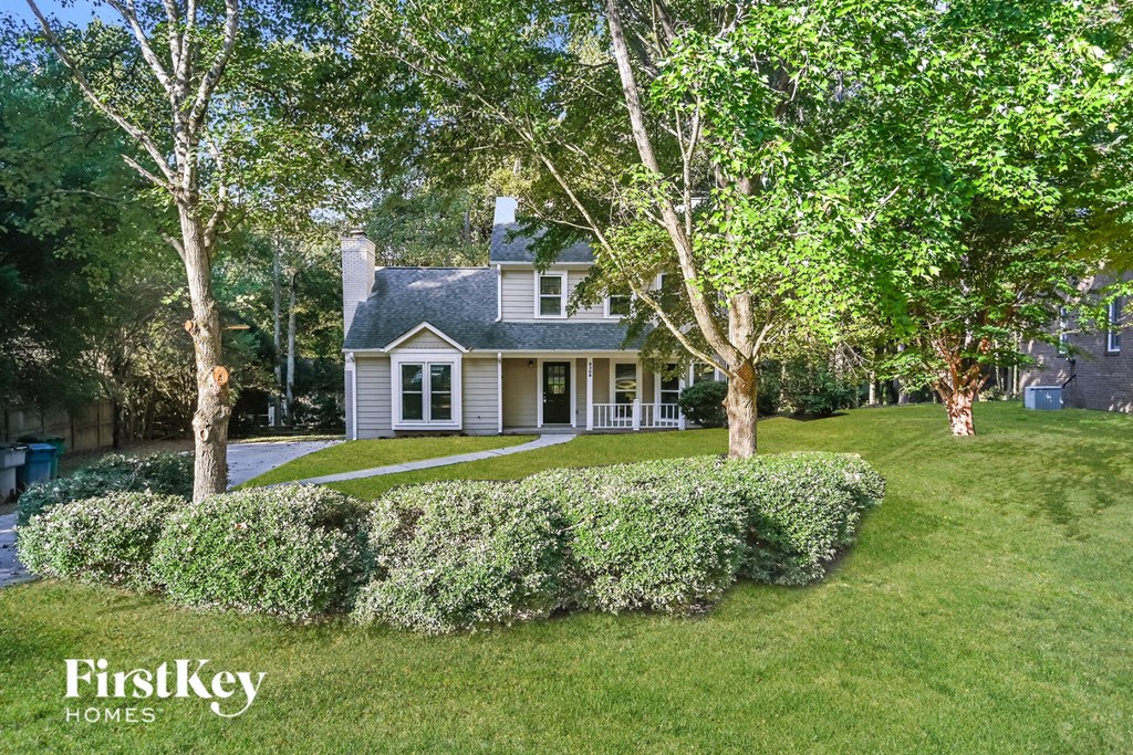 a home with a lawn and trees in front of it