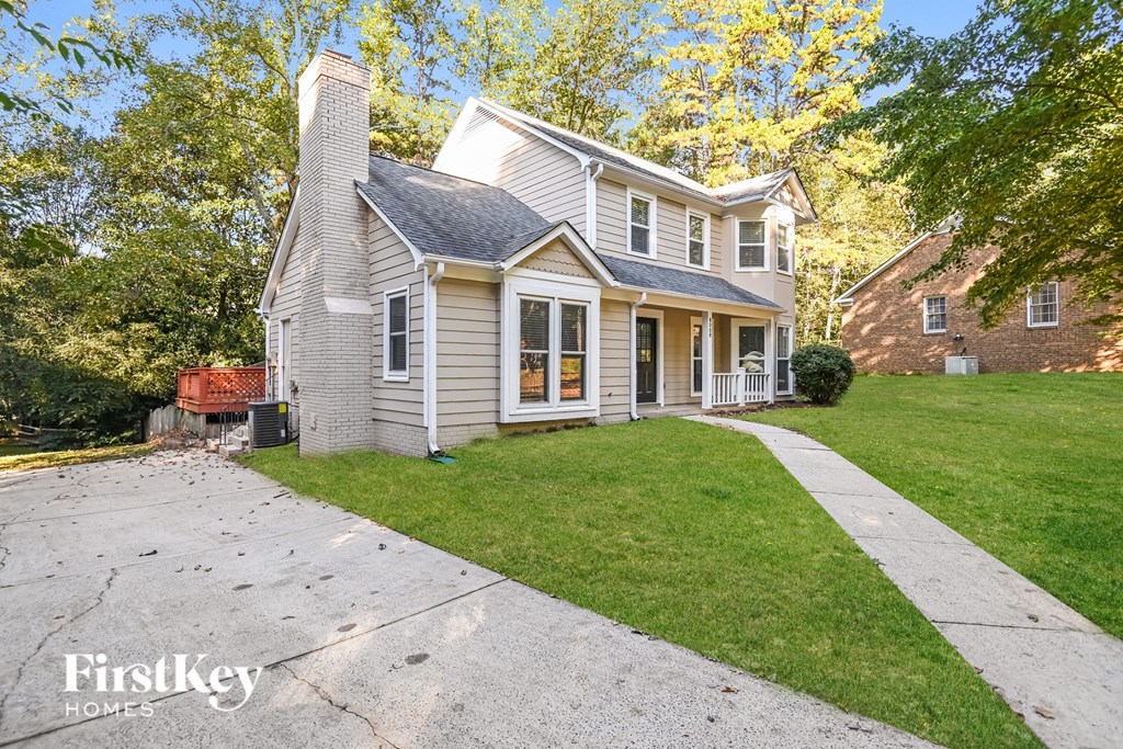 a white house with a yard and a sidewalk
