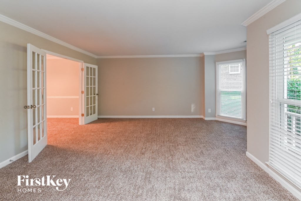 a bedroom with a carpeted floor and a door to a closet