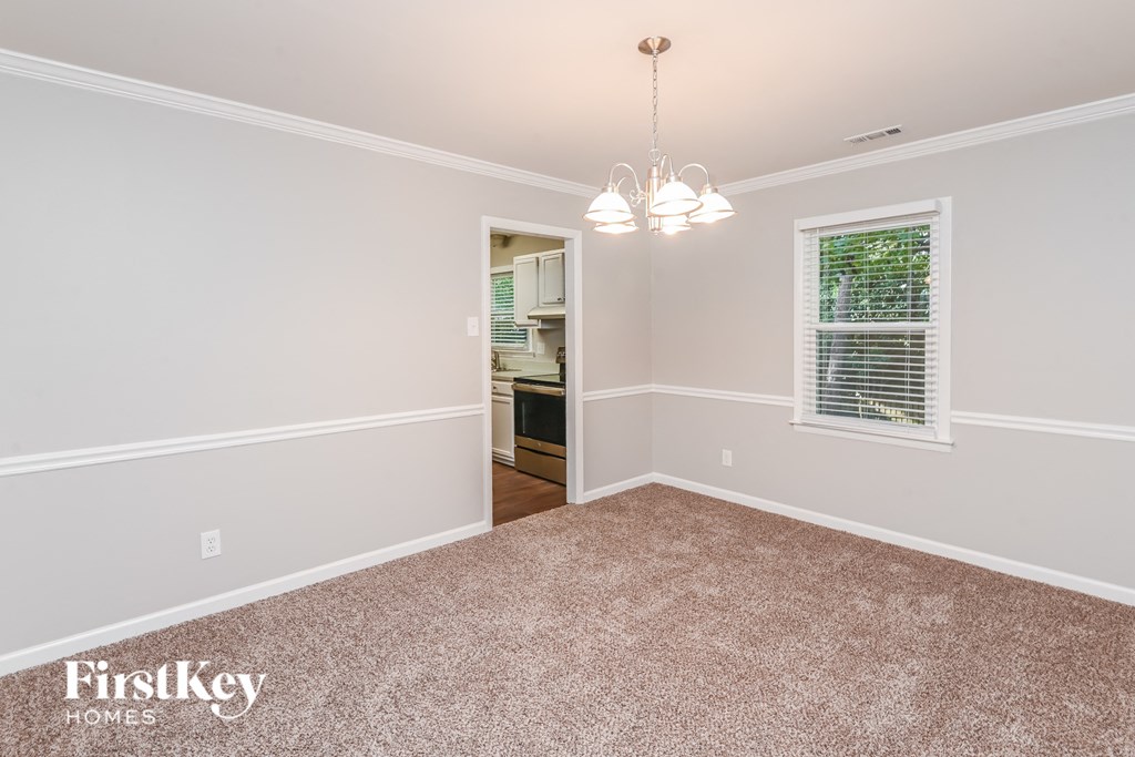 a bedroom with a carpeted floor and a door to a kitchen