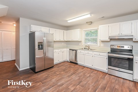 a kitchen with white cabinets and stainless steel appliances