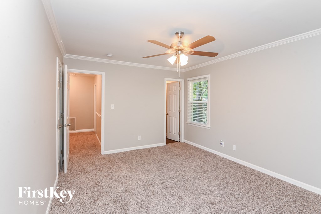 a bedroom with a ceiling fan and a door to a closet