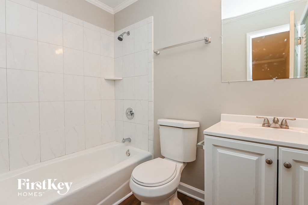 a white bathroom with a toilet and a tub and a sink