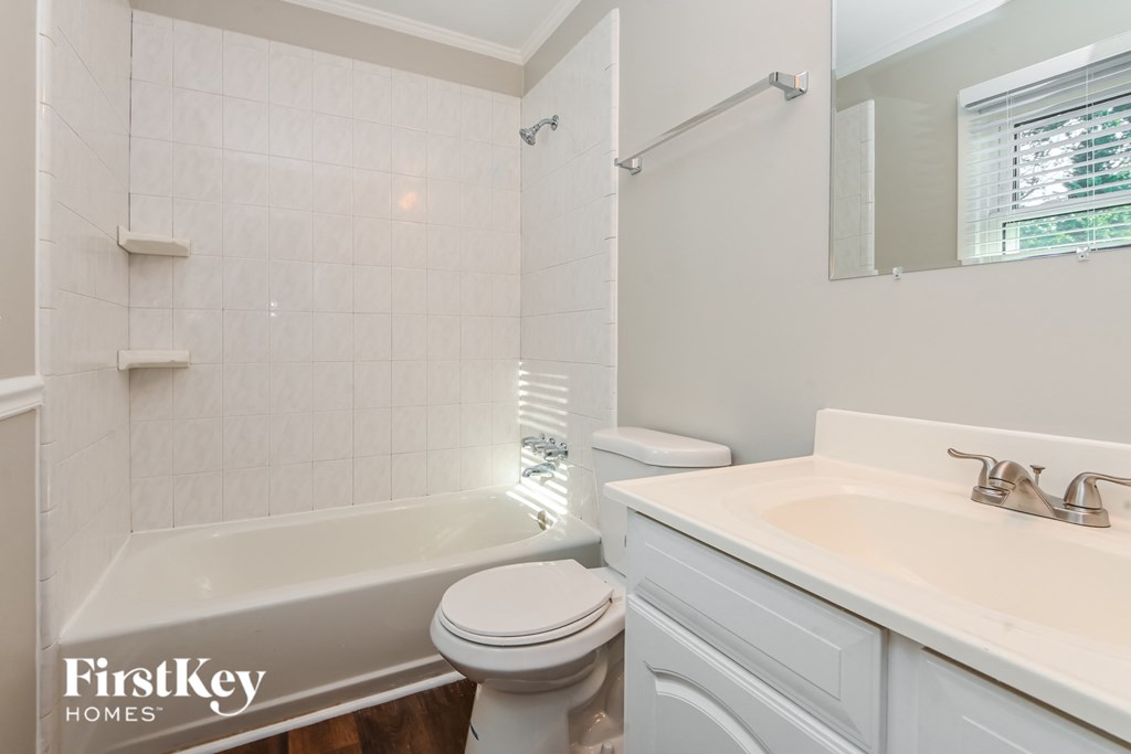 a white bathroom with a tub and a sink and a toilet