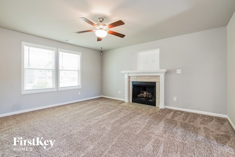 the living room with fireplace and ceiling fan