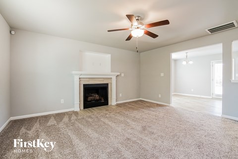 the living room with fireplace and ceiling fan