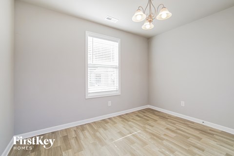 the living room of a new home with wood flooring and a window