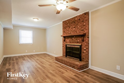 A room with a fireplace and a ceiling fan.