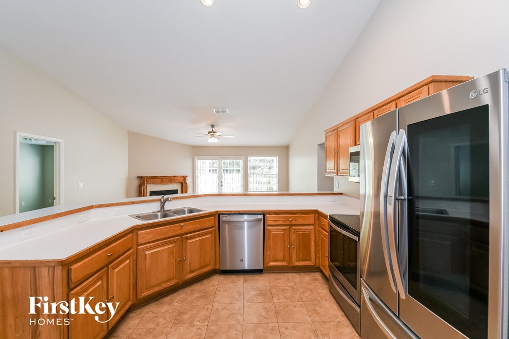A kitchen with wooden cabinets and a stainless steel refrigerator.