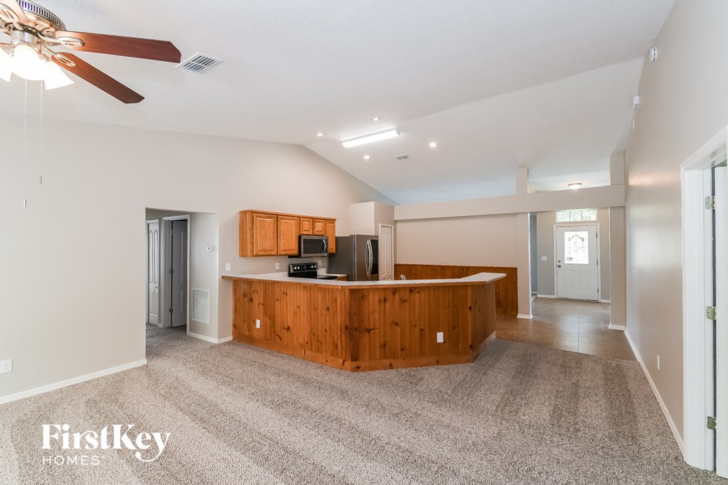 A spacious kitchen with wooden cabinets and a ceiling fan.