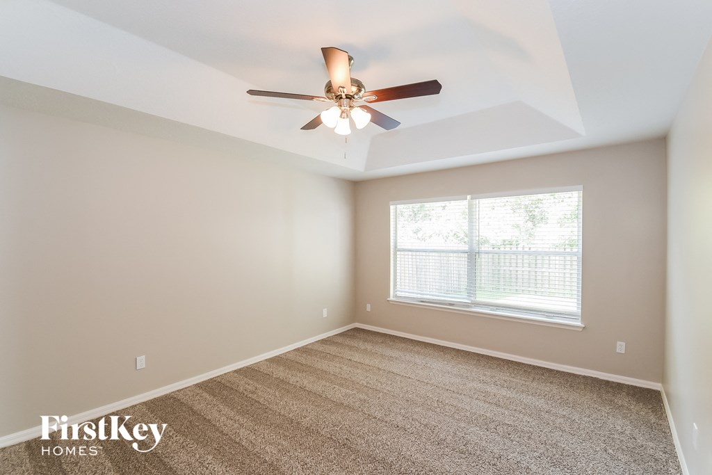 A room with a ceiling fan and a window.