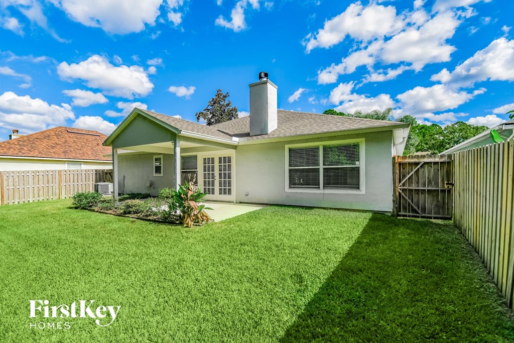 A white house with a green lawn in front of it.
