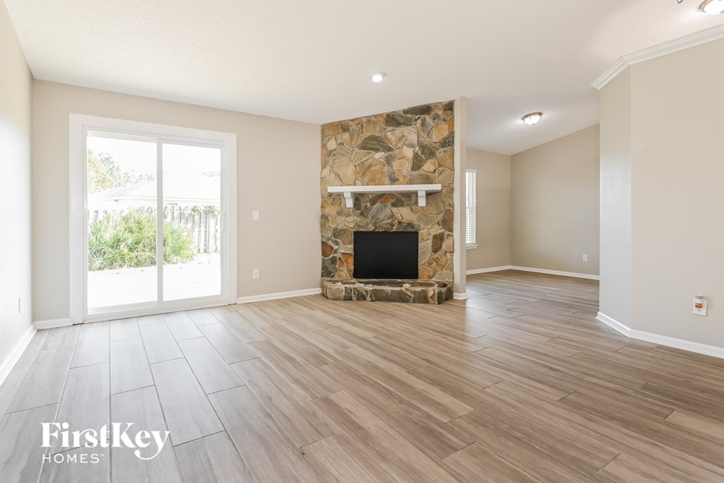 a living room with a fireplace and wooden floors