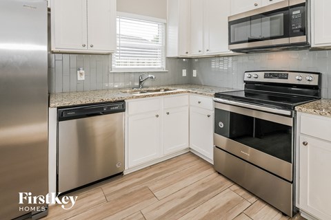 a kitchen with stainless steel appliances and white cabinets