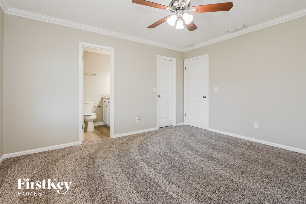 a bedroom with a carpeted floor and a ceiling fan