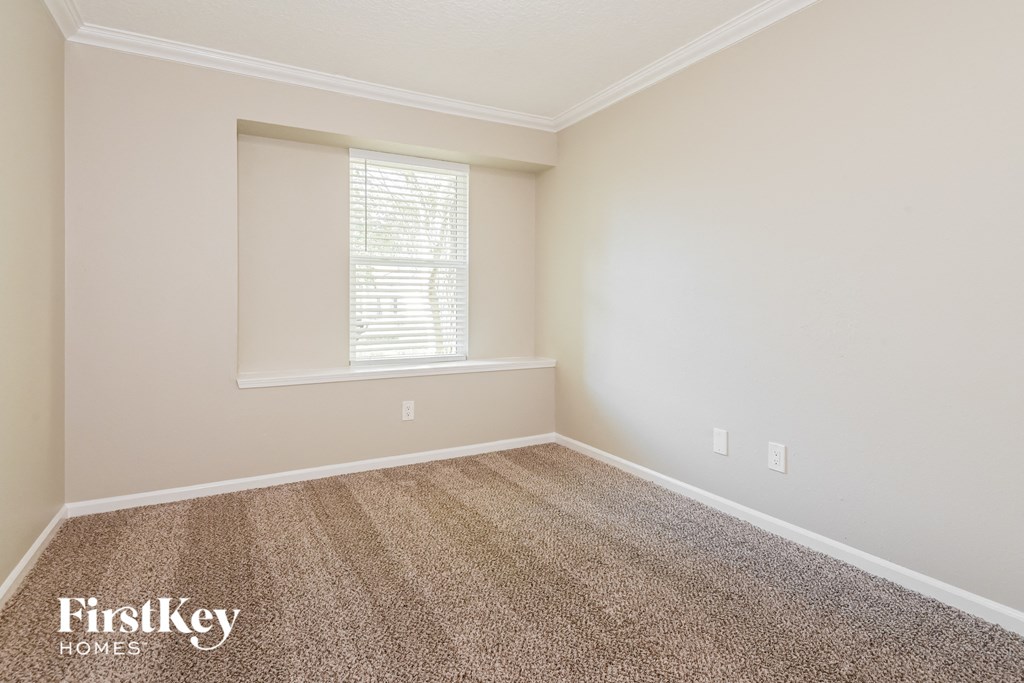 a empty room with carpet and a window