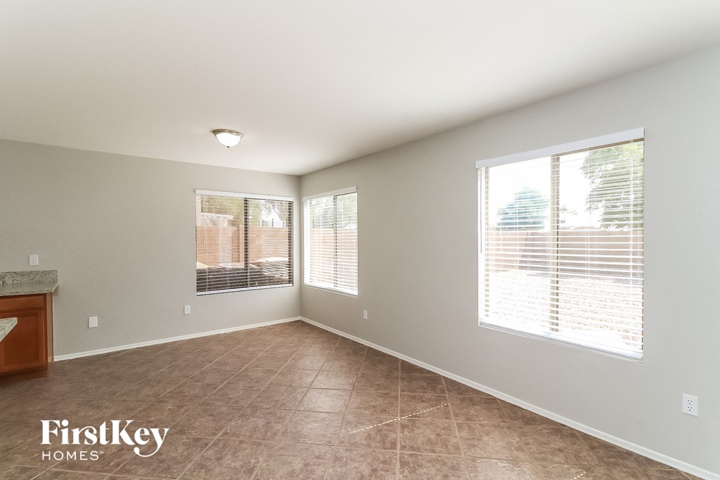 a spacious living room with two windows and a tiled floor