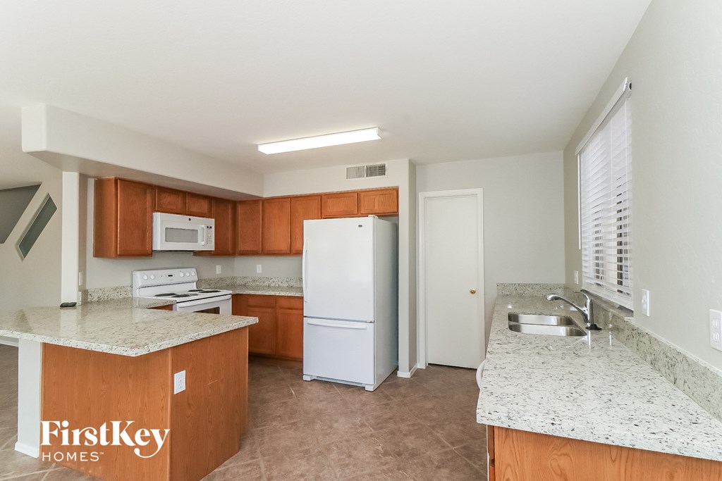 a kitchen with white appliances and granite counter tops