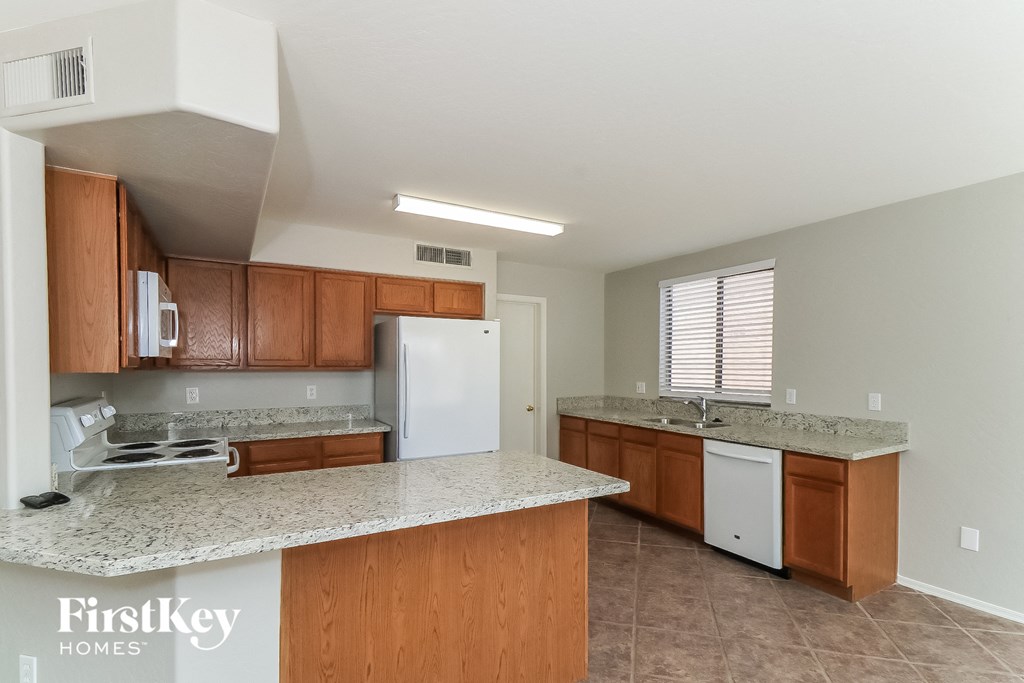 a kitchen with wooden cabinets and white appliances and granite counter tops