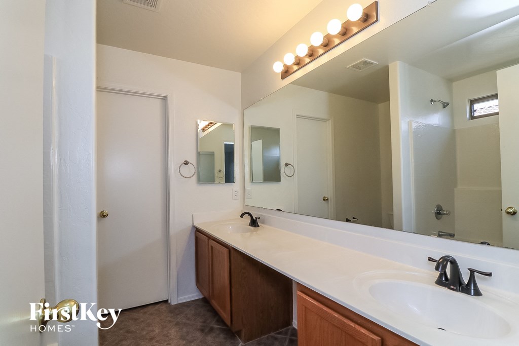 a bathroom with a white sink and a large mirror