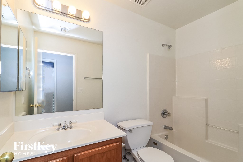a white bathroom with a mirror and a toilet and a sink
