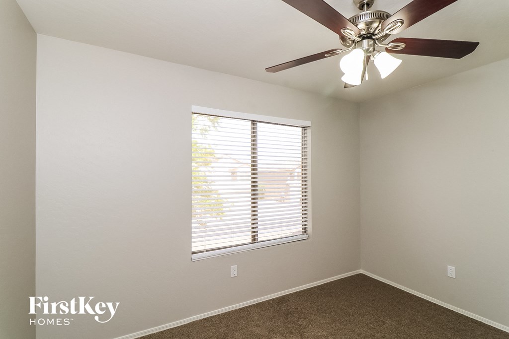 a bedroom with a ceiling fan and a window