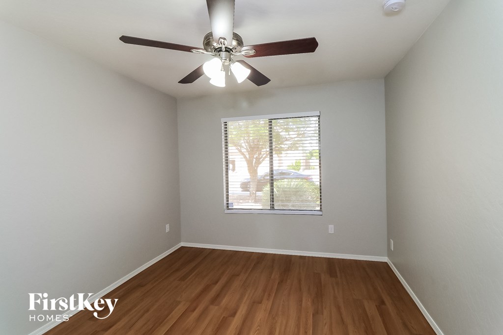 an empty room with a ceiling fan and a window