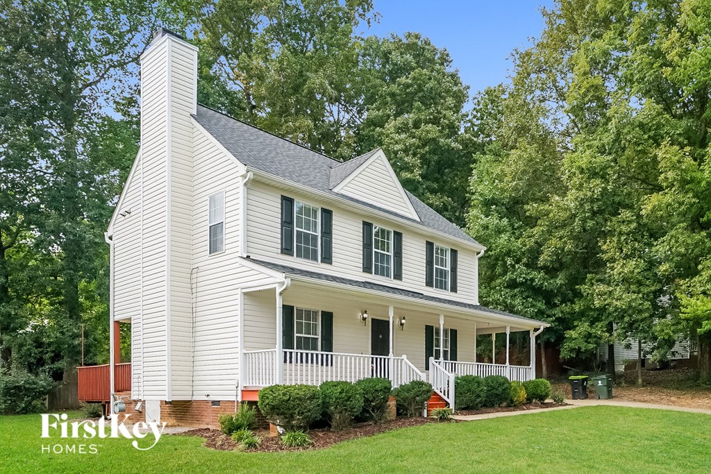 a white house with green trees and a lawn
