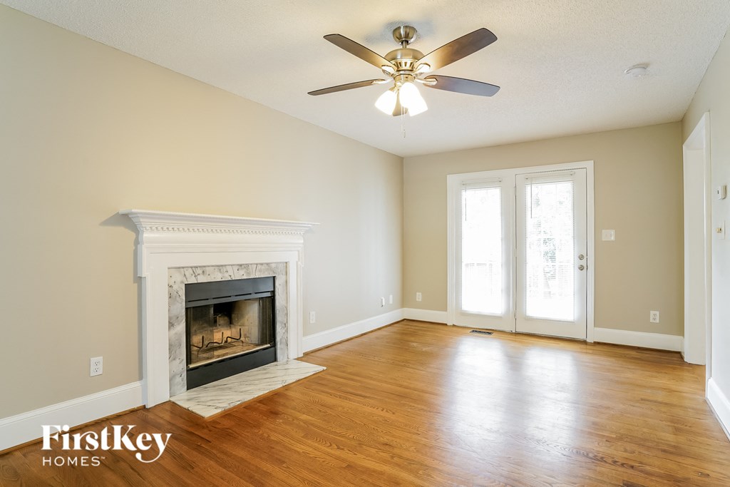 a living room with a fireplace and a ceiling fan