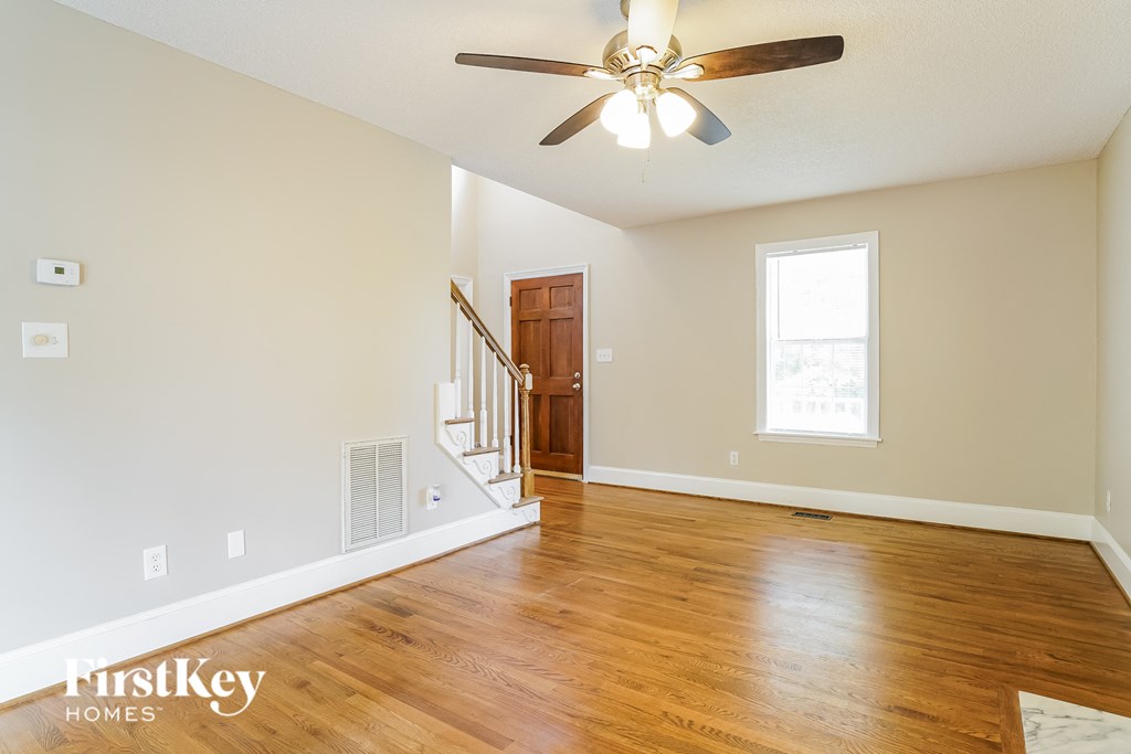 a living room with hardwood floors and a ceiling fan