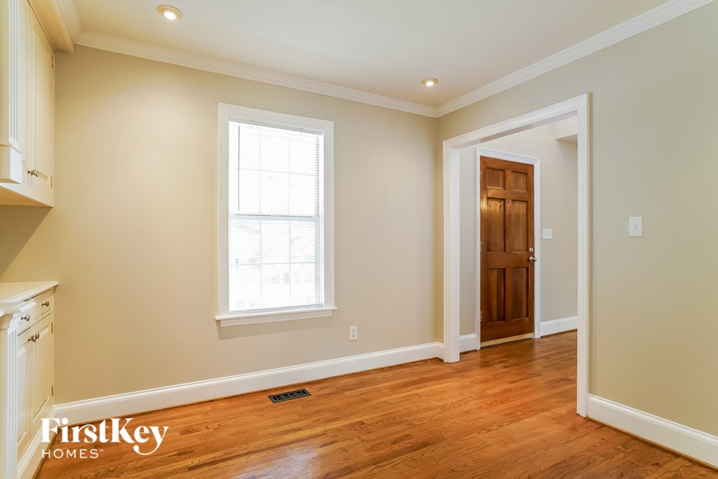 a living room with a wooden floor and a door and a window