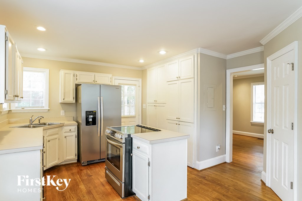 a kitchen with white cabinets and a stainless steel refrigerator