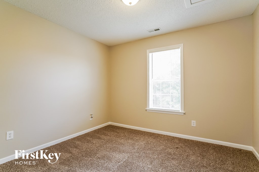 a bedroom with carpeted floors and a window