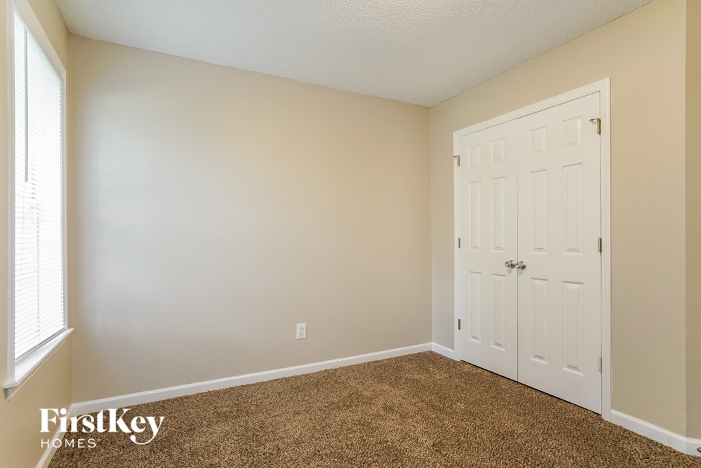 a bedroom with a white door and a carpeted floor