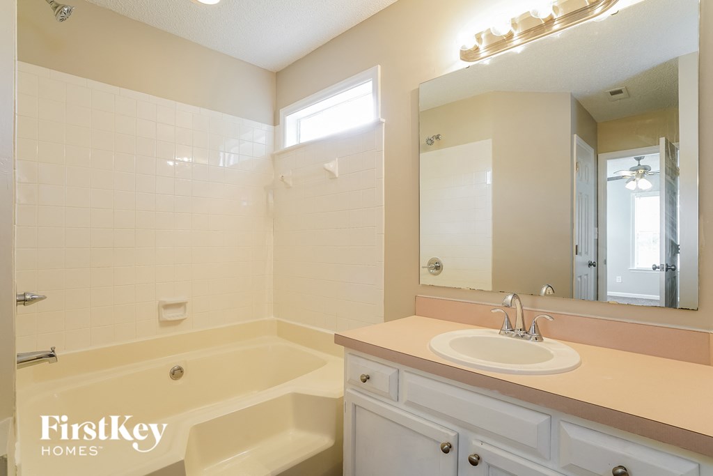 a bathroom with a tub and a sink and a mirror