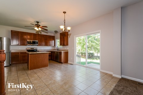 a kitchen with wooden cabinets and a sliding glass door to a patio