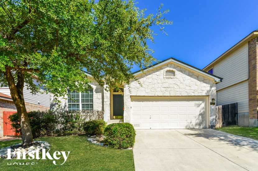 a home with a white garage door and a tree