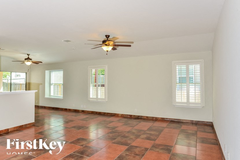 a kitchen with two ceiling fans and a tiled floor