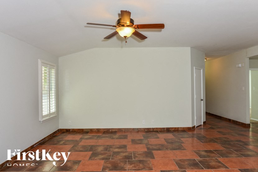 a living room with a ceiling fan and a white wall
