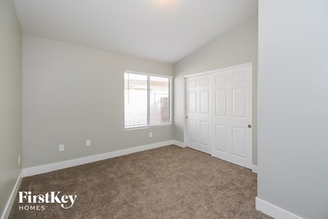 a bedroom with carpet and a white door and window