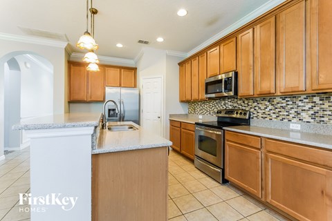 A kitchen with wooden cabinets and a white island.