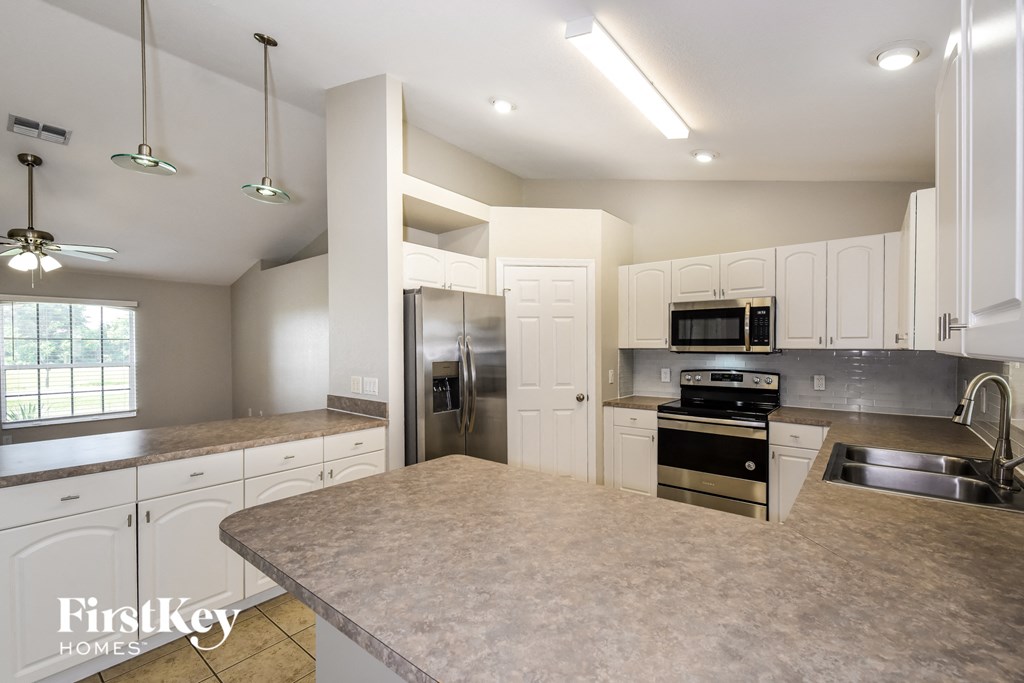 a kitchen with white cabinets and stainless steel appliances