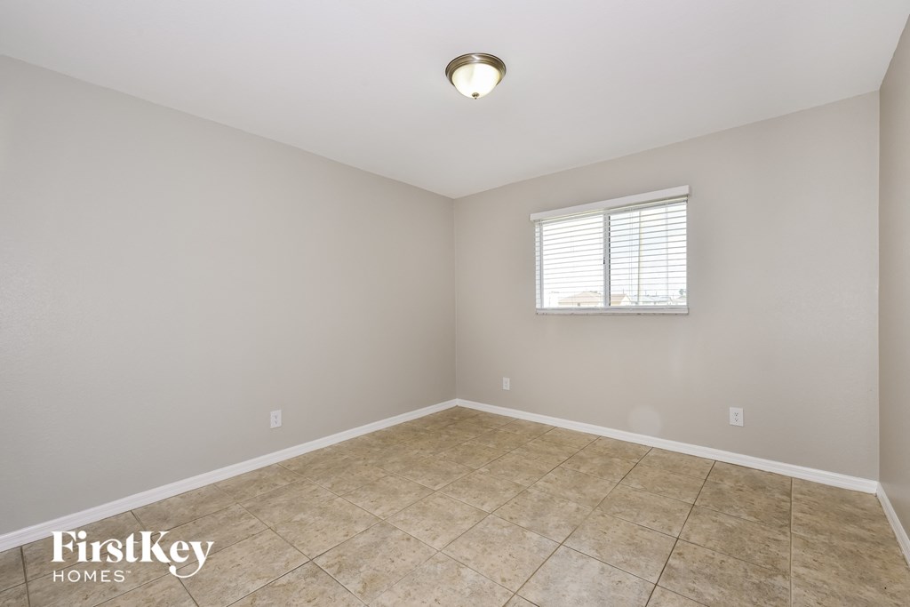 the spacious living room with tile flooring and a window