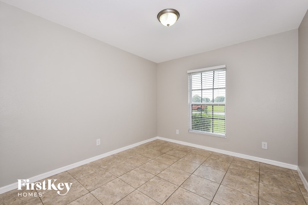 the spacious living room with tile flooring and a window