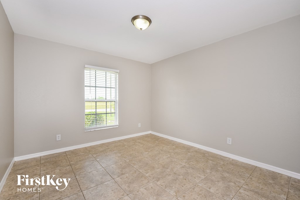 the spacious living room with tile flooring and a window